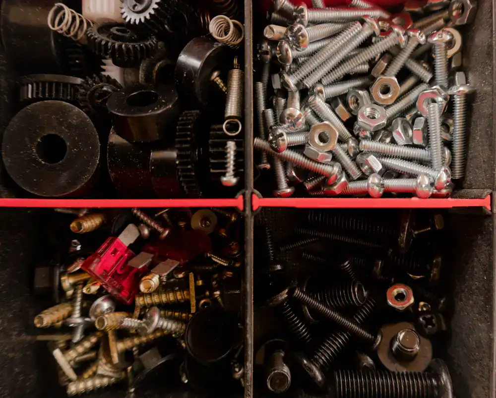 Close up of brass screws and steel bolts sorted in trays