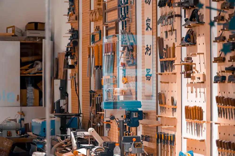 A clean, well-lit workbench featuring neatly arranged hand tools and brass fittings